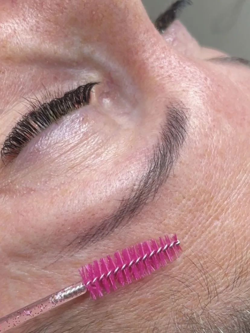 Healed microblading forming a defined tapered arch, hair brushed clear with a spoolie